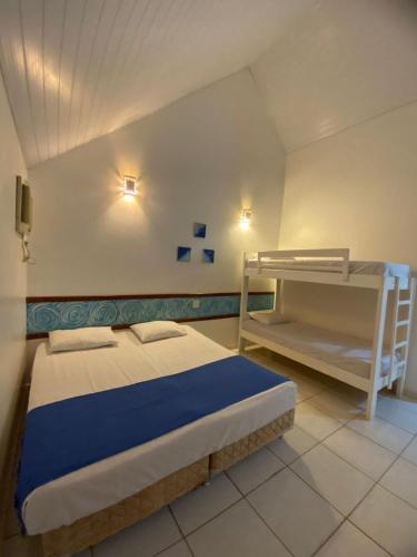 a bedroom with a bed and bunk beds in it at Pousada Chalés Jardim das Aguas in Olímpia