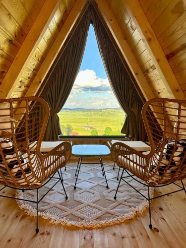 two chairs and a table in a room with a window at Monte zone Zabljak in Žabljak
