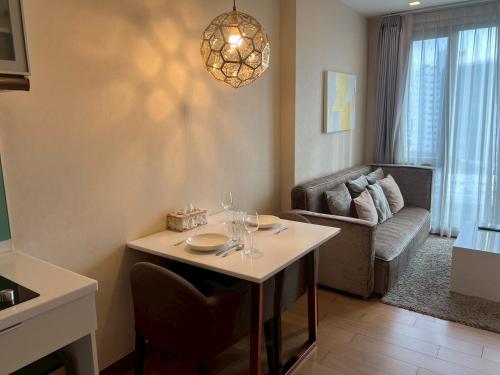 a living room with a table and a couch at The Astra Luxury Condo in Town in Chiang Mai