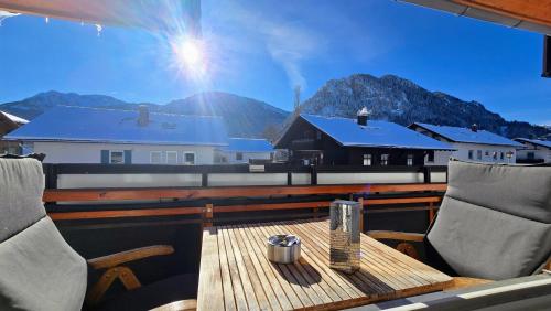 einen Tisch und Stühle auf einer Terrasse mit Bergblick in der Unterkunft Aggenstein - Helles Studio mit Südbalkon und traumhaftem Bergpanorama in Pfronten Mitte in Pfronten
