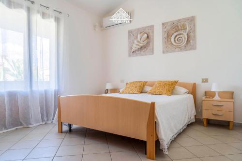 a bedroom with a bed and a large window at Casa Torre di Nora - Morada in Pula