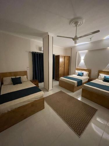 una camera da letto con due letti e un tappeto di Luxe Nest Guest House Apartment 22 a Luxor