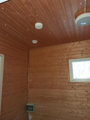Traditional Finnish Lapland house at wild forest backyard! في كيمي: غرفة بجدران خشبية ونافذة