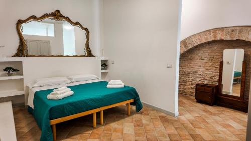een slaapkamer met een bed met een spiegel aan de muur bij The Gualdo Hideaway in Gualdo Tadino