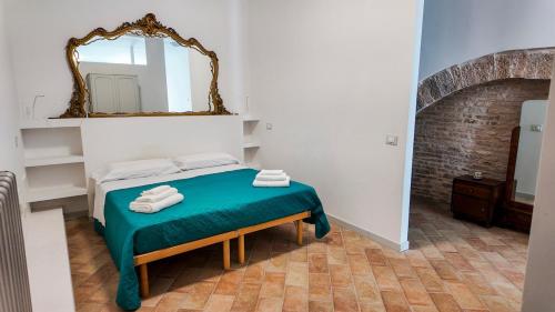 een slaapkamer met een bed met een spiegel aan de muur bij The Gualdo Hideaway in Gualdo Tadino