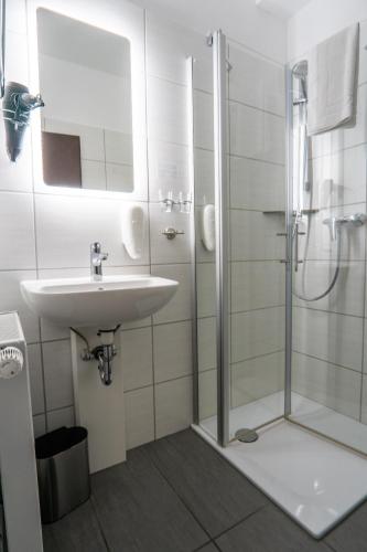 a bathroom with a sink and a shower at Reichels Parkhotel in Bad Windsheim