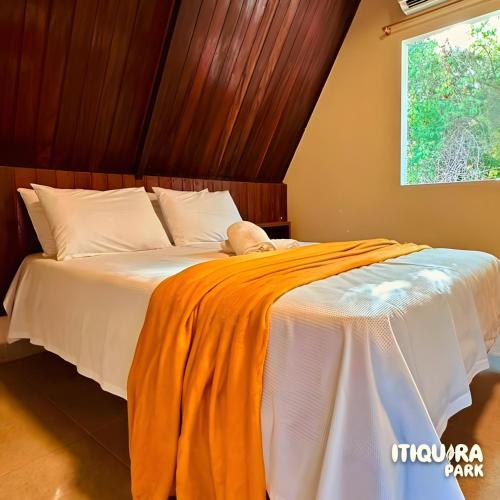 a bed with an orange blanket on it at Itiquira Park Hotel in Formosa