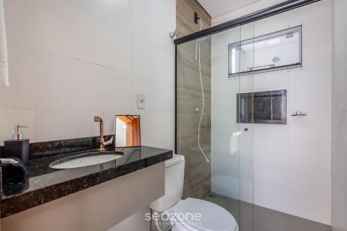a bathroom with a toilet and a sink and a shower at Apto c/ churrasqueira a 190m da Praia MBU0102 in Barra Velha