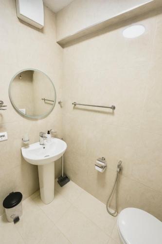 a bathroom with a sink and a mirror and a toilet at New Bazaar Cozy Villa in Tirana