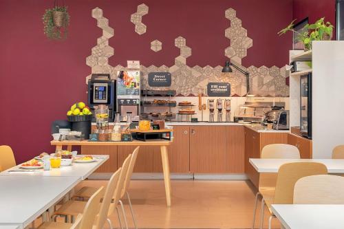 Un restaurante de comida rápida con paredes y mesas rojas. en B&B Hotel Como Camerlata, en Como