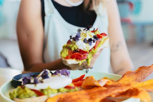 una mujer sosteniendo un pedazo de comida con papas fritas en Palmar Beach Lodge, en Bocas Town