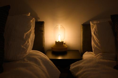 a lamp sitting on a table next to two beds at Stowe Hideout in Hilton