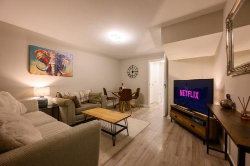a living room with a couch and a tv at Stowe Hideout in Hilton