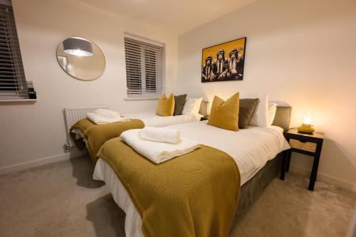 a bedroom with two beds with yellow sheets and a mirror at Stowe Hideout in Hilton