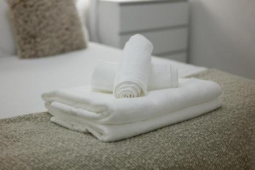 a pile of white towels sitting on top of a bed at Stowe Hideout in Hilton