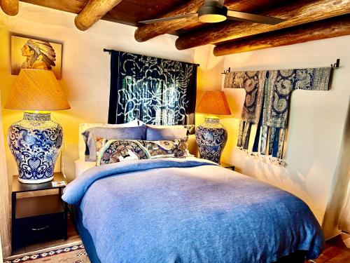 una camera con un letto blu e bianco e due lampade di Historic Adobe 1 acre compound ultimate Santa Fe immersion Classic & Dreamy a Santa Fe