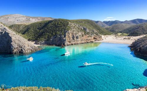 dos barcos en un cuerpo de agua al lado de una playa en Casa vacanze Ginevra Sardegna, en Fluminimaggiore