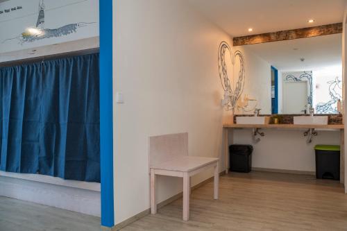 Habitación con silla y espejo. en WOT Ericeira Surf Social, en Ericeira
