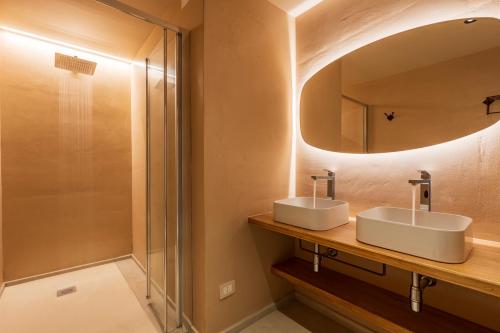 La salle de bains est pourvue de 2 lavabos et d'un miroir. dans l'établissement Sogno, à Tortolì