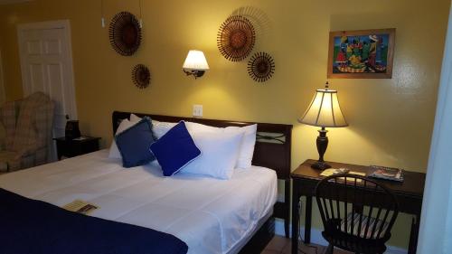 a bedroom with a bed and a desk with a lamp at The Caribbean Court Boutique Hotel in Vero Beach