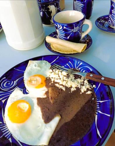 een blauw bord met een stuk cake met eieren erop bij Hotel - CABAÑAS THAJU - HUASTECA POTOSINA in El Naranjito