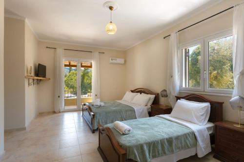 a bedroom with two beds and a window at Elite Villa Dio in Áno Korakiána