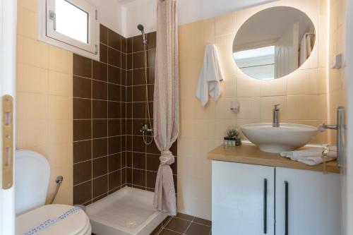 a bathroom with a toilet and a sink and a mirror at Elite Villa Dio in Áno Korakiána