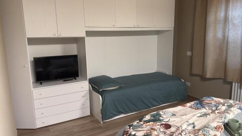 a small bedroom with a bed and a tv at Podere Gorette in Poggibonsi
