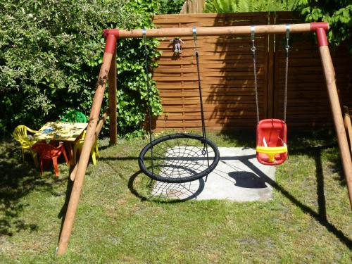 a swing set in a yard with a table and a chair at Orzechowa Przystań in Ustka