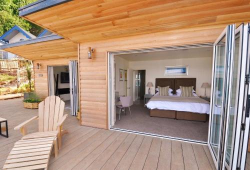 a master bedroom with a bed and a deck at Cary Arms & Spa in Torquay
