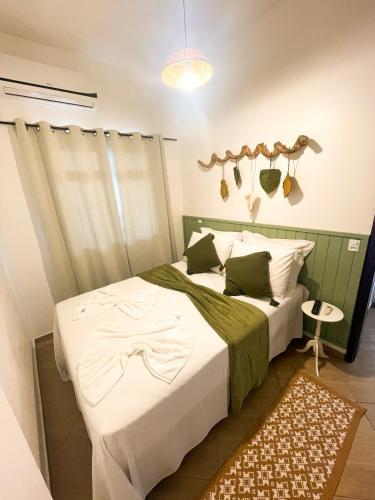 a bedroom with a bed with a shirt on it at Moradas da Bibi in Guarda do Embaú