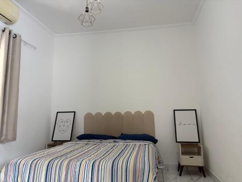a bedroom with a bed and two mirrors on the wall at Casa próximo à rodoviária e centro in Rondonópolis