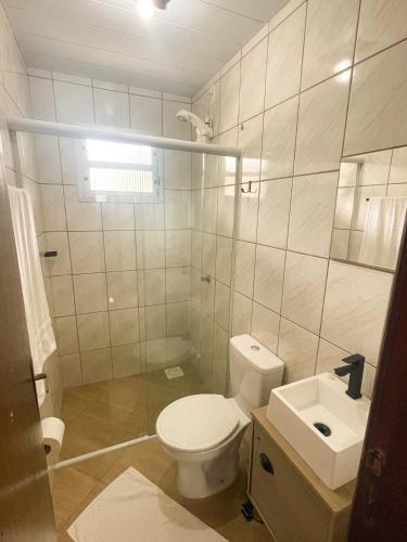 a bathroom with a toilet and a sink at Moradas da Bibi in Guarda do Embaú