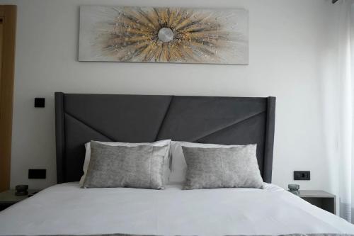 a bedroom with a white bed with a black headboard at Monte zone in Žabljak