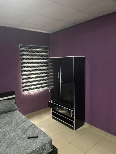 Egbeda vics guests house的一间带床和紫色墙壁的卧室