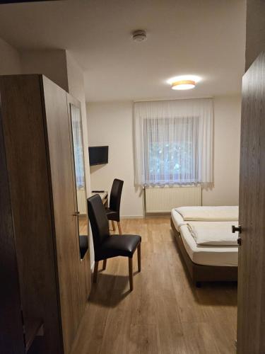 ein Schlafzimmer mit Bett, Stuhl und Schreibtisch in der Unterkunft Hotel - Restaurant Baumann in Freiberg am Neckar