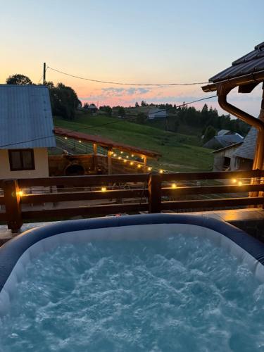 a hot tub on a deck with a sunset at Pensiunea agro-turistica Maris in Bogdăneşti