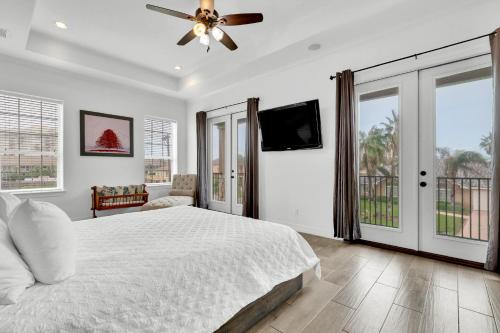 a bedroom with a bed and a ceiling fan at Paradise Villa: 2 blocks from beach, private pool in South Padre Island