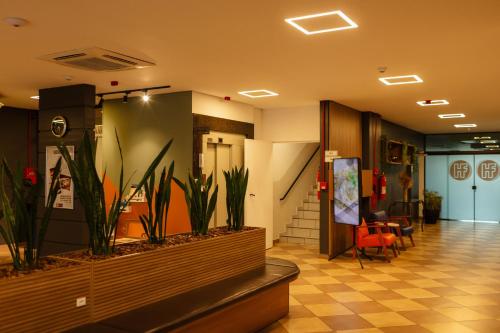a lobby with plants in the middle of a building at Hotel Ferraz in Pouso Alegre