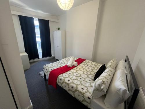 a bedroom with a bed with a red blanket at The Down Town Chambers in Bournemouth