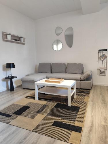 Duplex spacieux et lumineux en centre-ville في شاتودون: غرفة معيشة مع أريكة وطاولة قهوة