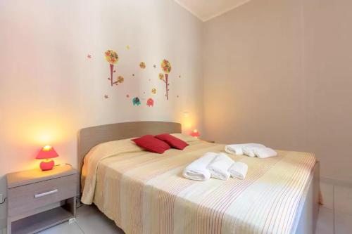 a bedroom with a bed with two towels on it at Casa Red & Blue in Castellammare del Golfo