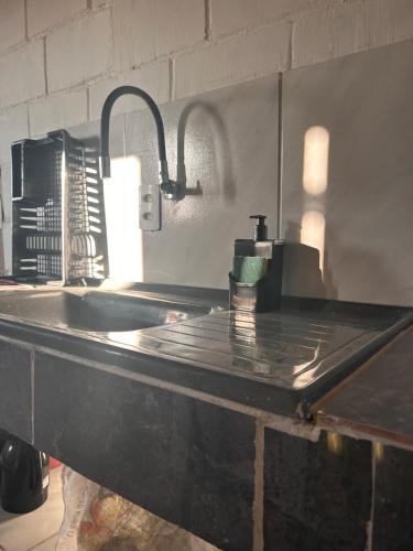 uma bancada de cozinha com um lavatório e um lavatório em Raizes do bem estar em Lucena