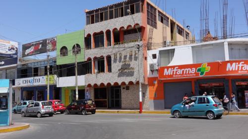 una strada di città con auto parcheggiate di fronte agli edifici di Hotel Las Lineas a Nazca
