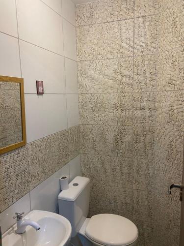 a bathroom with a white toilet and a sink at Sabrina · Duplex com excelente localização, em Muriqui in Mangaratiba