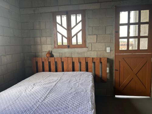 um quarto com uma cama e uma porta de madeira em Raizes do bem estar em Lucena