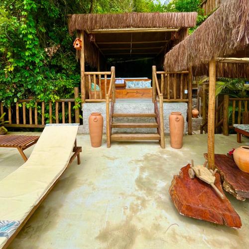 a resort room with a bed and a swing at Eliza, Bangalô vista mar em Trancoso in Trancoso