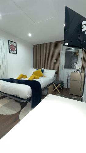 a bedroom with a large bed with yellow pillows at Kaira's Nook in Wolverton