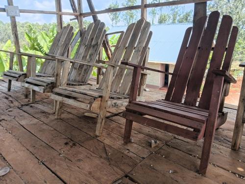 a group of wooden chairs sitting on a deck at Miale Guests Cottages in Kiamuringa