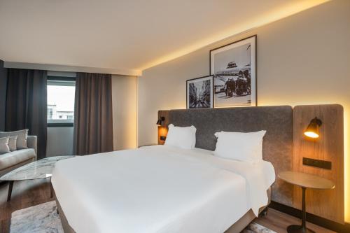 ロワシー・アン・フランスにあるGolden Tulip CDG Airport Roissyのベッドルーム(大きな白いベッド1台、ガラスのテーブル付)